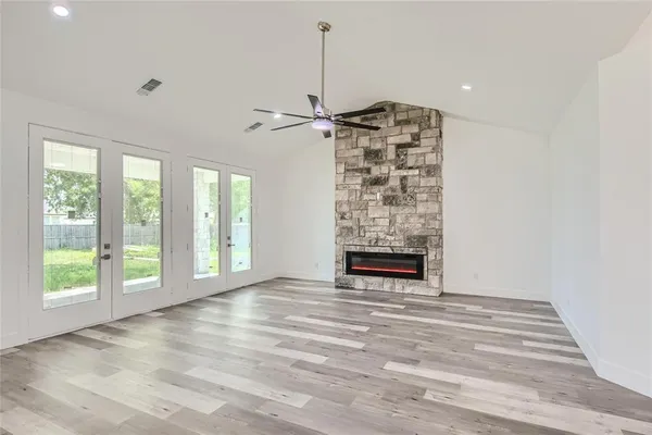 a view of an empty room with a window and a fireplace