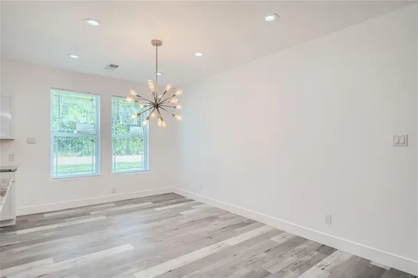 en empty room with windows and ceiling fan