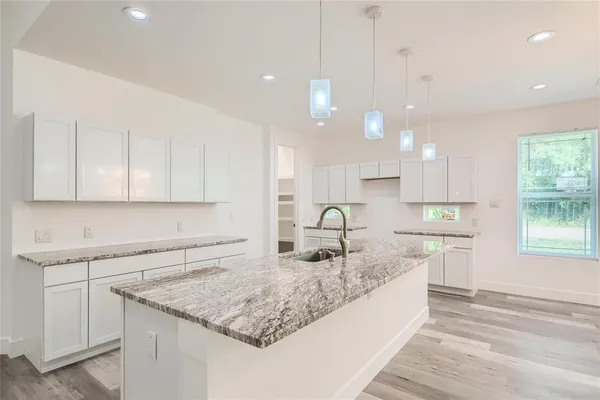 a large kitchen with kitchen island a sink stainless steel appliances and cabinets