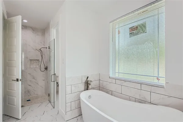 a bathroom with a bathtub and shower