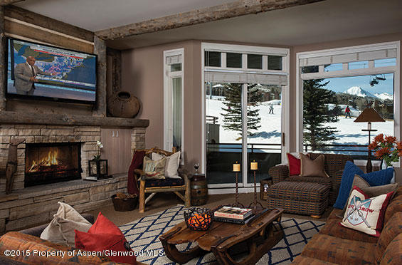 a living room with furniture a fireplace and a floor to ceiling window