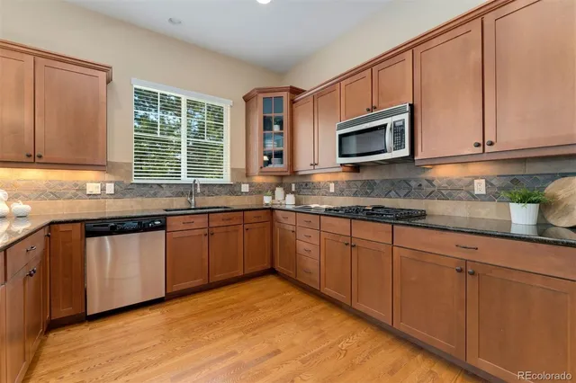 a kitchen with granite countertop cabinets stainless steel appliances a sink and window