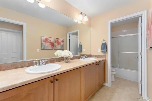 a bathroom with a granite countertop sink two mirror and a shower
