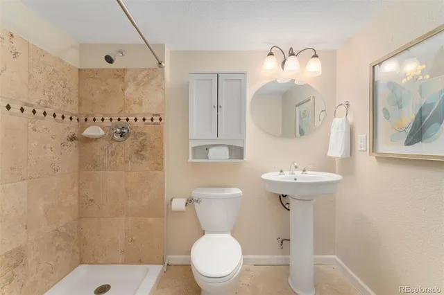 a bathroom with a sink toilet and shower