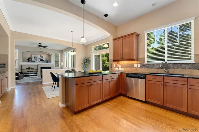 a kitchen with stainless steel appliances granite countertop wooden floors sink and cabinets