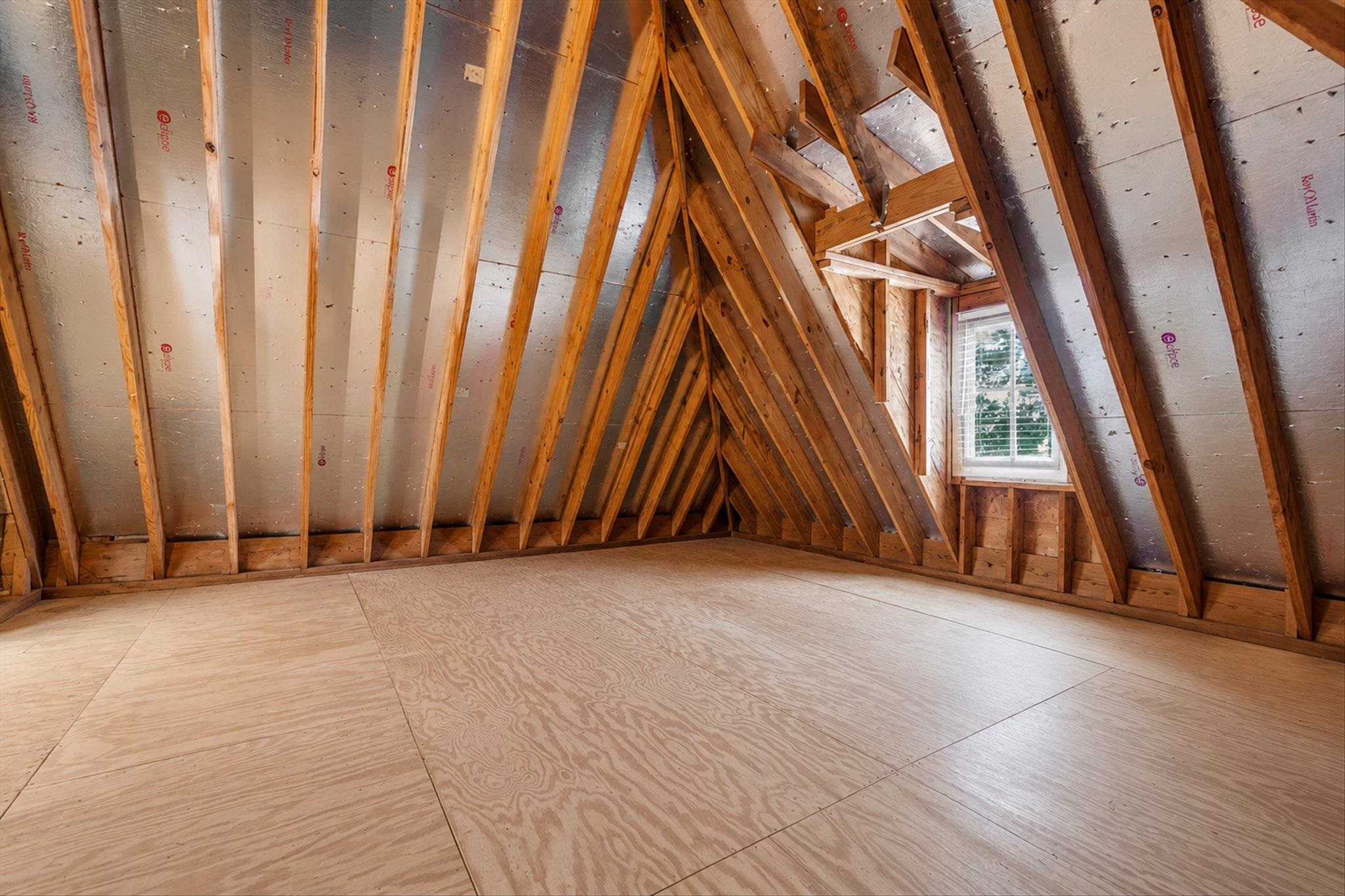 3246 North Hartwell Ridge Drive Collierville, TN 38017 - Photo 35 of 40 Unfinished attic space featuring exposed wood framing, plywood flooring, and a single pane window with white blinds