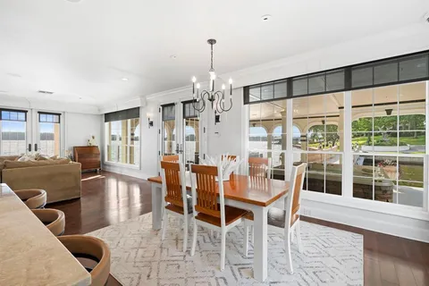 a kitchen with stainless steel appliances kitchen island granite countertop a stove and white cabinets with wooden floor