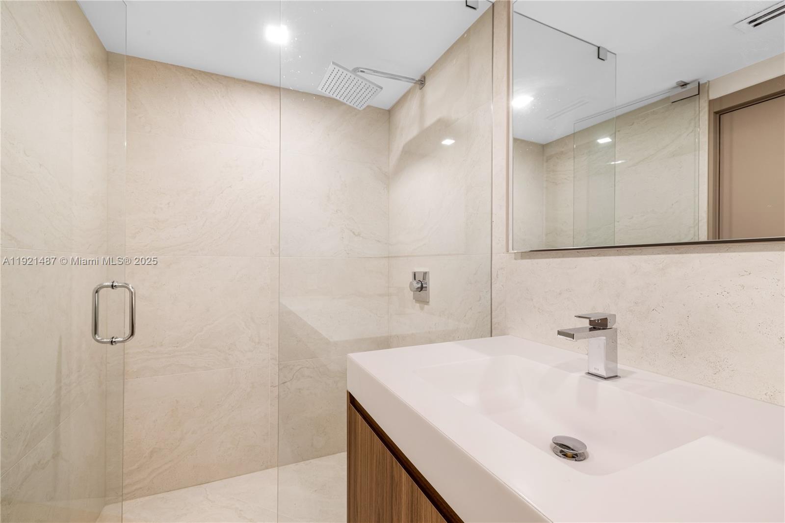 10155 Collins Avenue, Unit 202 Bal Harbour, FL 33154 - Photo 43 of 50 a bathroom with a sink a shower and a mirror