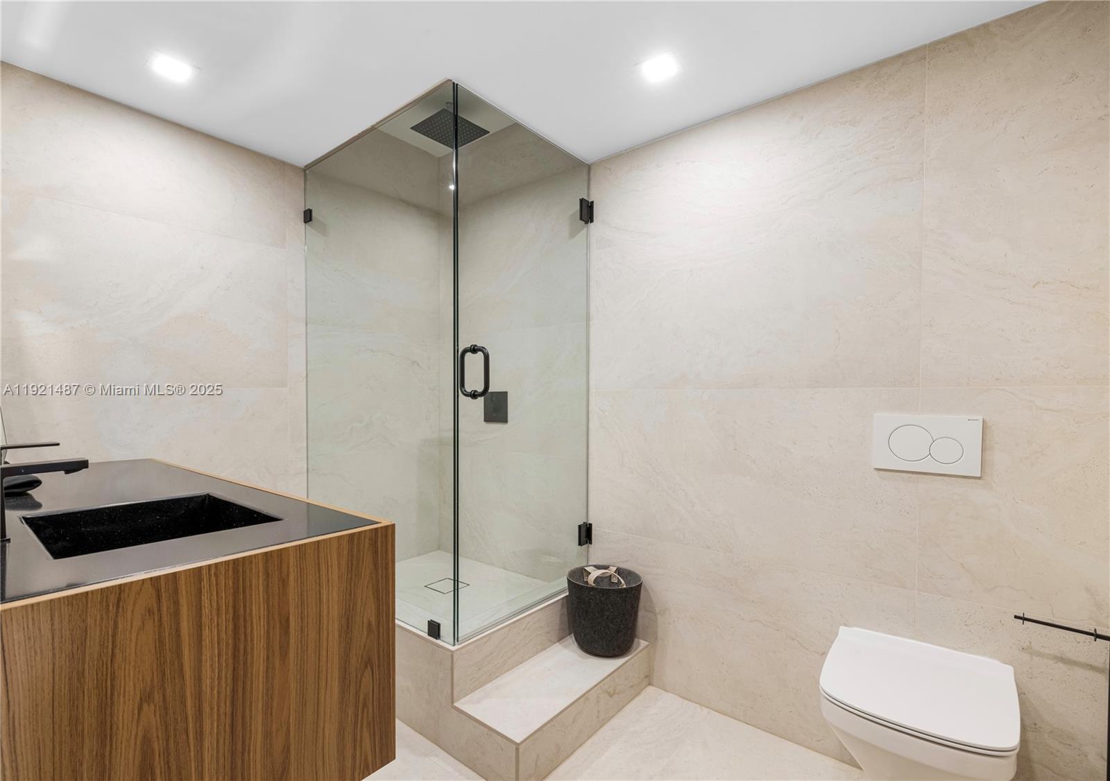 10155 Collins Avenue, Unit 202 Bal Harbour, FL 33154 - Photo 46 of 50 a bathroom with a sink a toilet a shower and a mirror