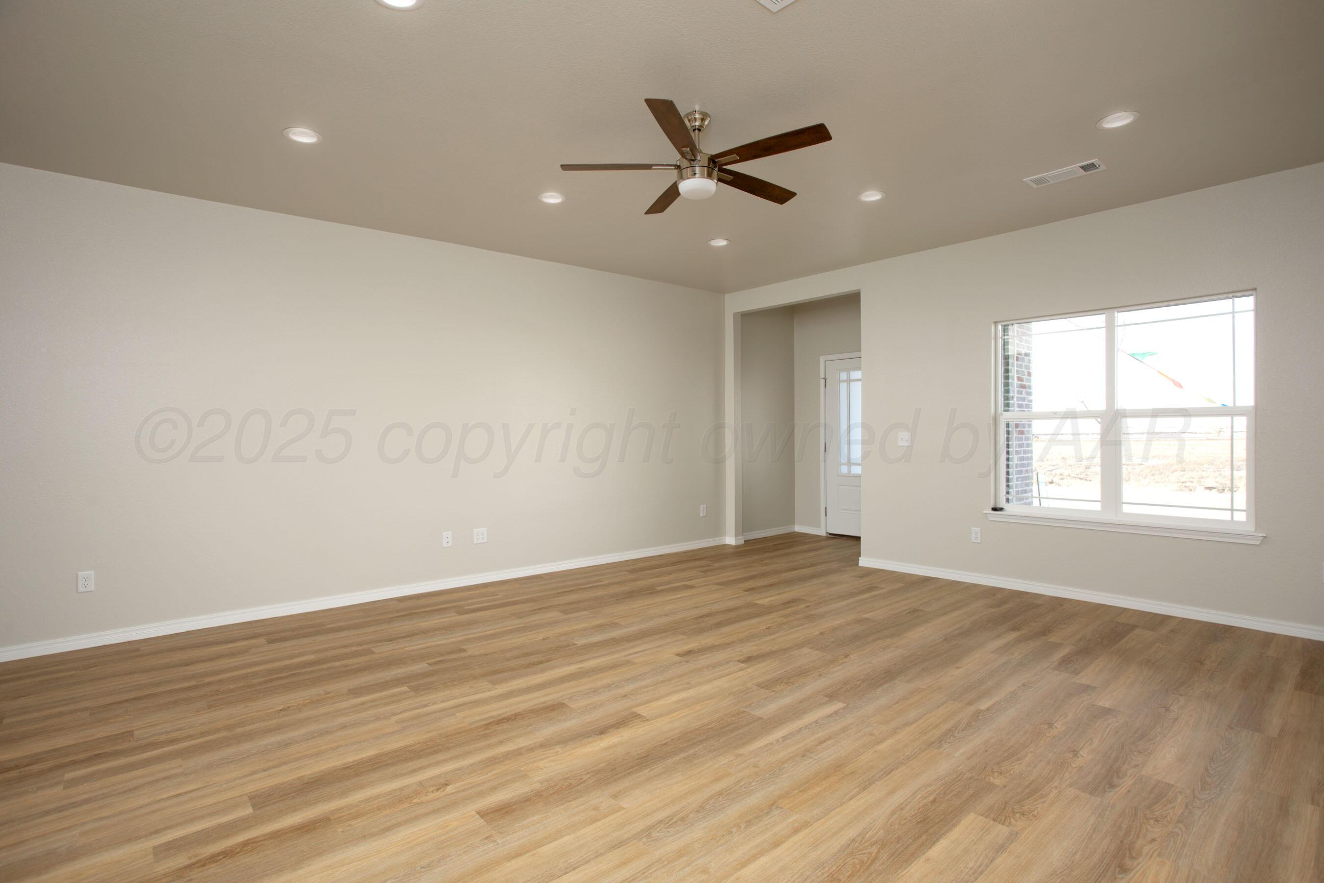 22111 Howard Draw Road Canyon, TX 79015 - Photo 12 of 25 an empty room with wooden floor and windows
