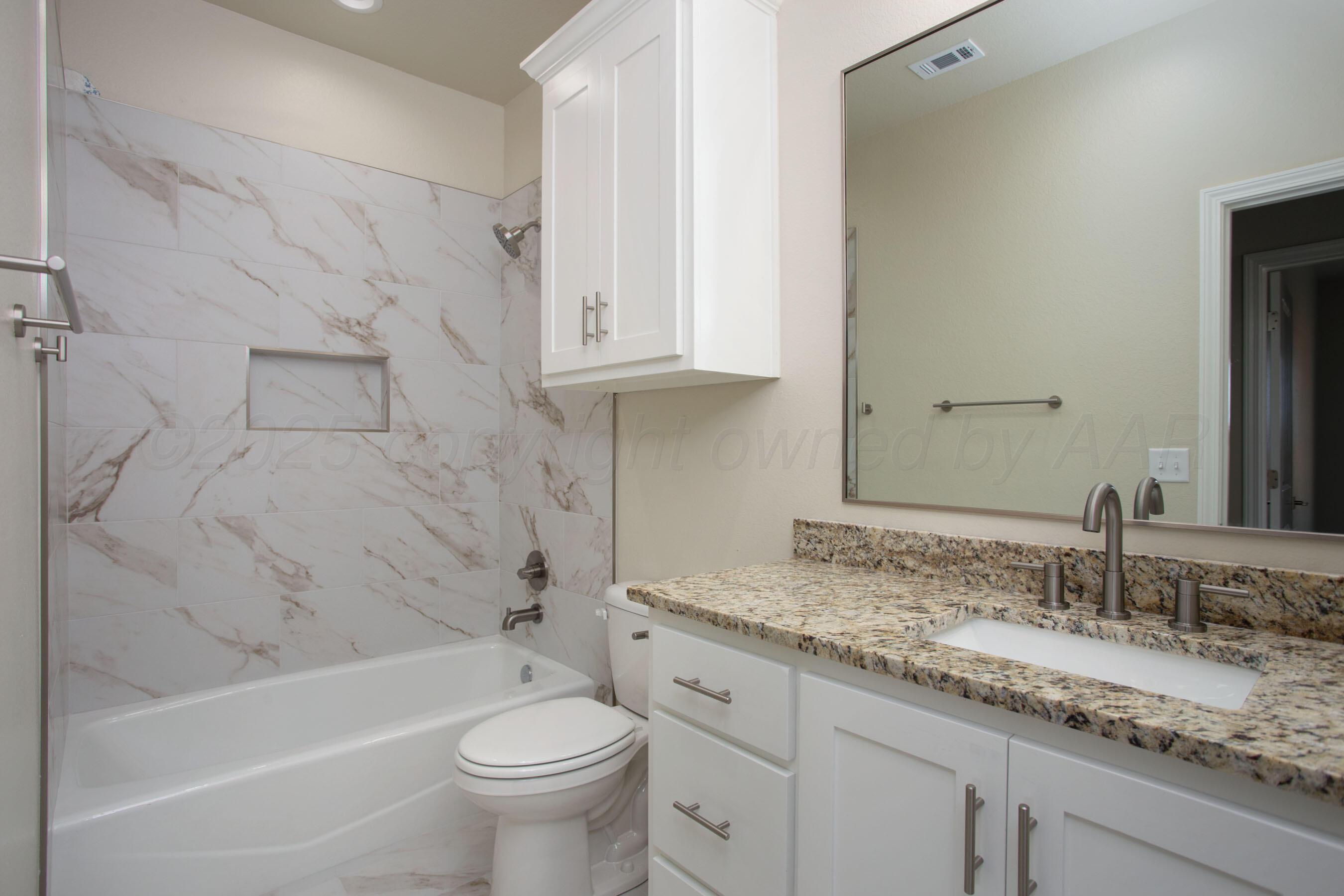 22111 Howard Draw Road Canyon, TX 79015 - Photo 22 of 25 a bathroom with a granite countertop sink a toilet and bathtub