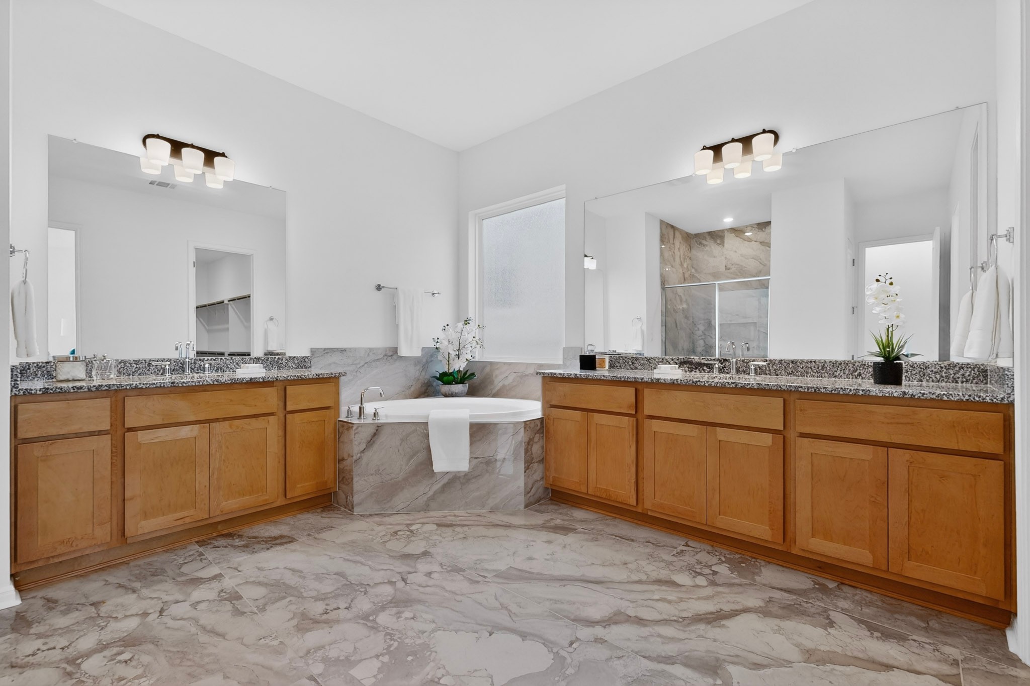 2308 Mondello Path Leander, TX 78641 - Photo 14 of 39 Marble flooring and spacious vanity areas define this primary bathroom retreat.