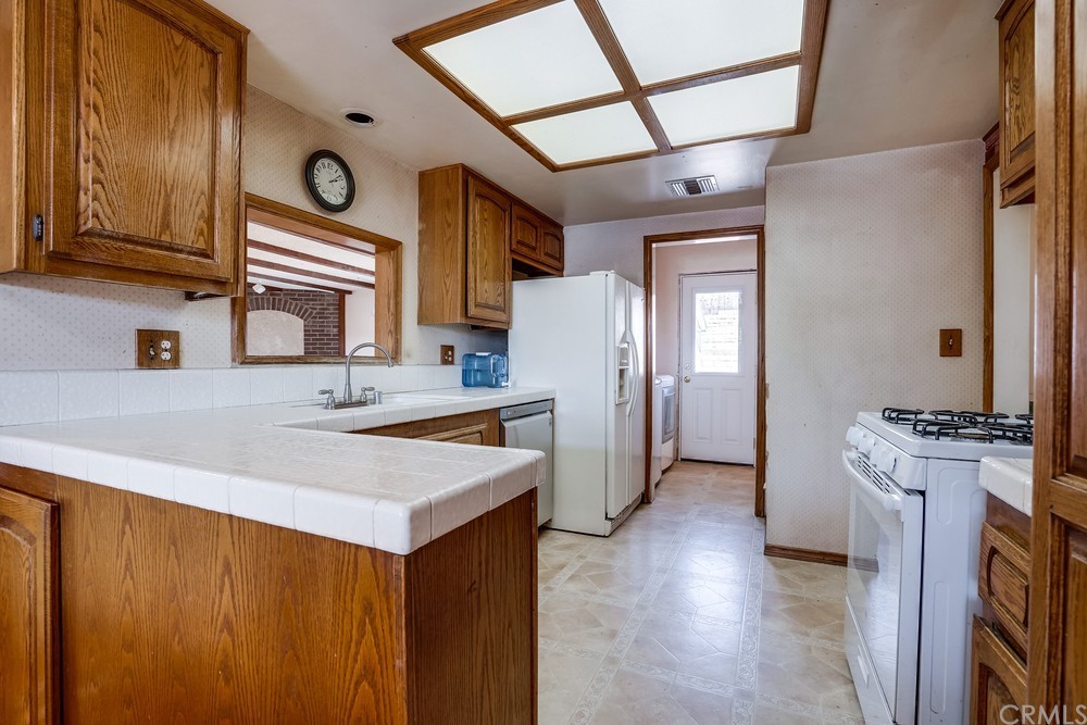 612 Lyford Drive La Verne, CA 91750 - Photo 12 of 44 a kitchen with stainless steel appliances granite countertop a refrigerator a stove and a sink with wooden floor