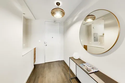 a view of a livingroom with wooden floor and a bathroom