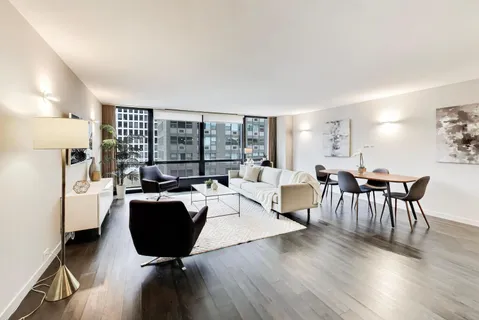a living room with furniture a table and a large window