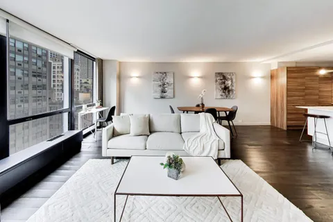 a living room with furniture wooden floor and a large window