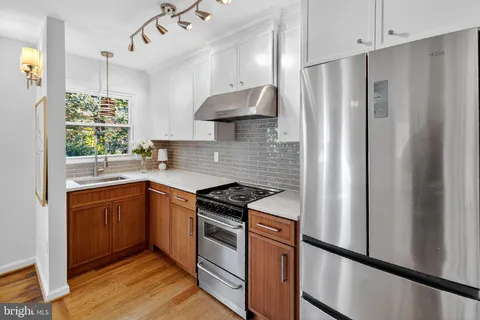a kitchen with stainless steel appliances granite countertop a refrigerator stove and sink