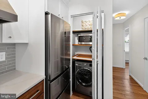 a utility room with wooden floor washer and dryer
