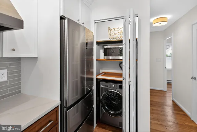 a utility room with wooden floor washer and dryer