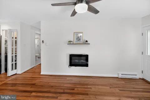 a view of a livingroom with wooden floor and a ceiling fan