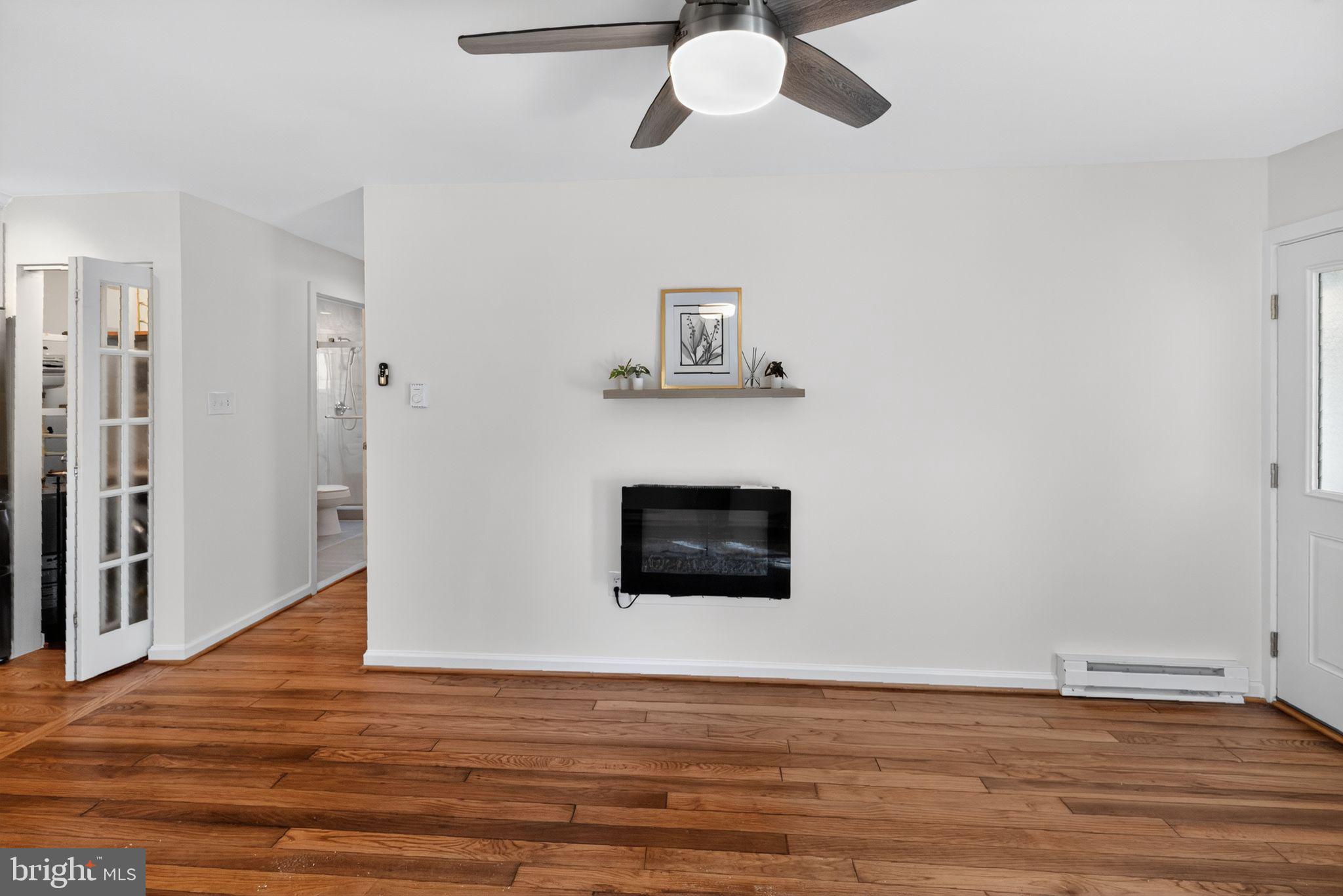 20 Hillside Road Greenbelt, MD 20770 - Photo 9 of 22 a view of a livingroom with wooden floor and a ceiling fan