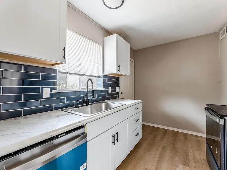 1735 R Avenue Plano, TX 75074 - Photo 3 of 8 Functional galley-style layout offers ample counter space, abundant storage, and natural light.Deep SS sink complemented by a modern gooseneck faucet and subway tile backsplash.