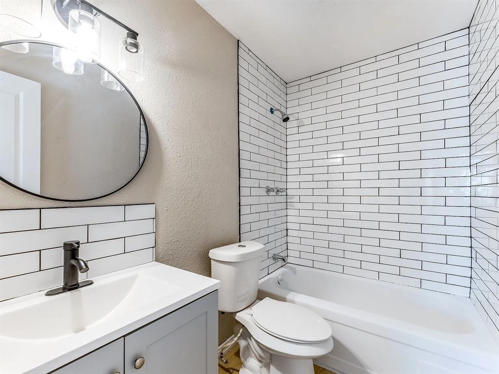 1735 R Avenue Plano, TX 75074 - Photo 5 of 8 Renovated bathroom features a modern vanity with integrated sink, updated lighting, and a tub/shower combo with tile surround.