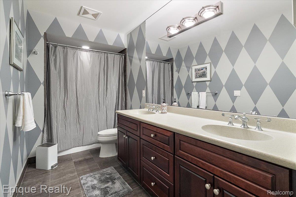7662 Devins Ridge Clarkston, MI 48348 - Photo 80 of 81 Bathroom featuring a double vanity with wood cabinetry and light-toned countertops