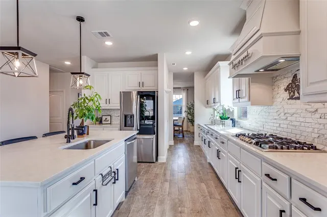 a kitchen with kitchen island granite countertop a sink stove and refrigerator