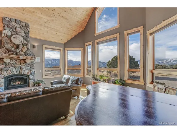 a living room with furniture large windows and fireplace