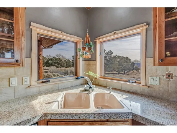 a room with two large window and a couch