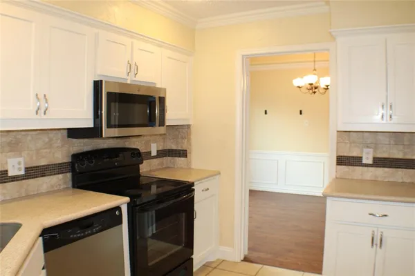 a kitchen with a sink and a stove top oven with wooden floor
