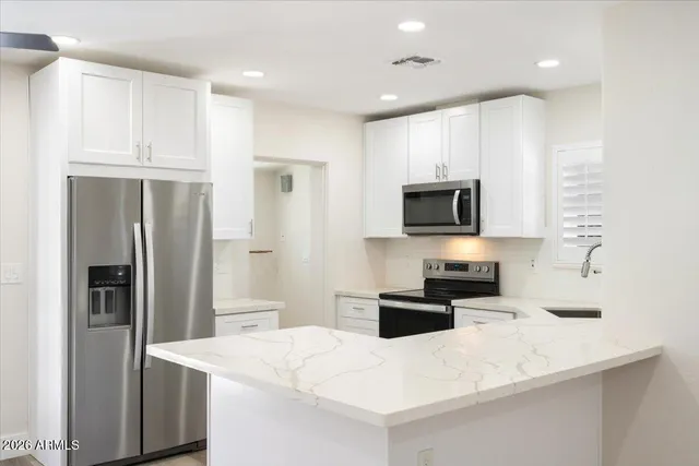 a kitchen with stainless steel appliances a refrigerator sink and microwave