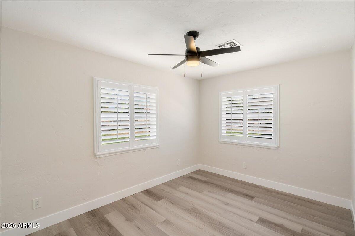Undisclosed Address Phoenix, AZ 85013 - Photo 9 of 16 a view of an empty room with wooden floor and a window
