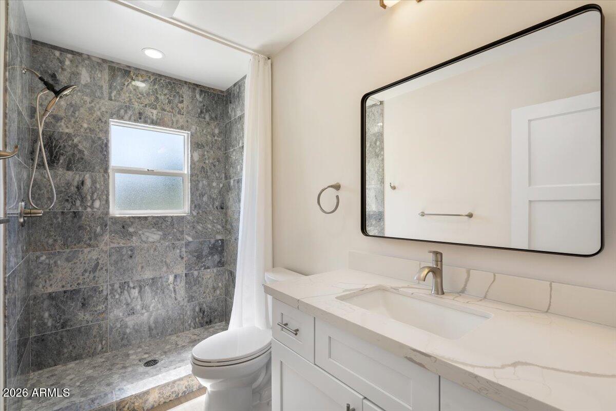 Undisclosed Address Phoenix, AZ 85013 - Photo 10 of 16 a bathroom with a granite countertop sink a toilet and a mirror