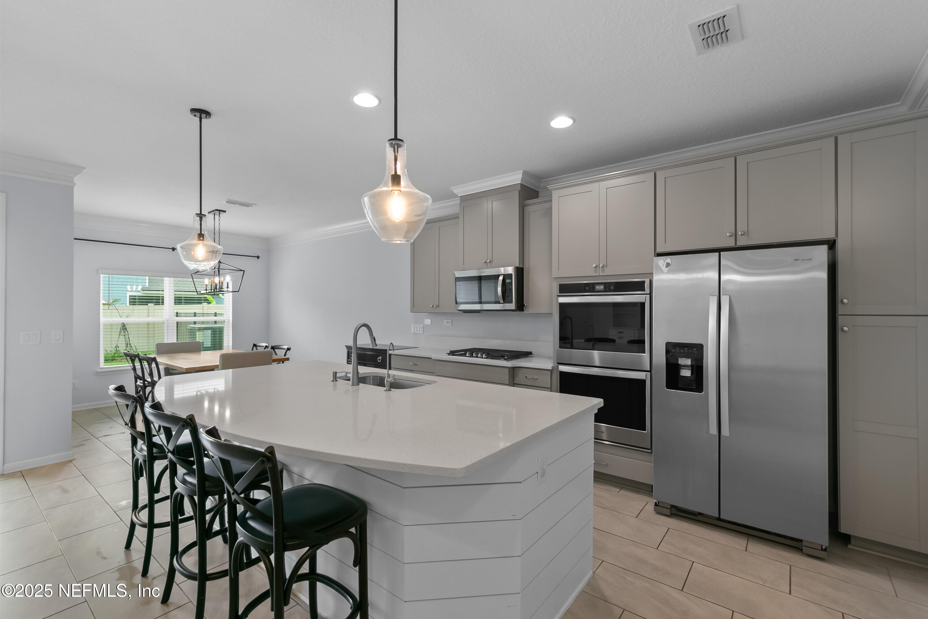 247 Beale Avenue St. Augustine, FL 32092 - Photo 8 of 62 a kitchen with kitchen island a refrigerator a stove a dining table and chairs