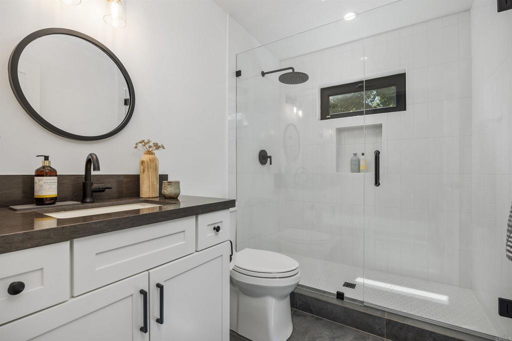 602 Sereno View Road Encinitas, CA 92024 - Photo 30 of 34 a bathroom with a toilet a sink a mirror and a shower