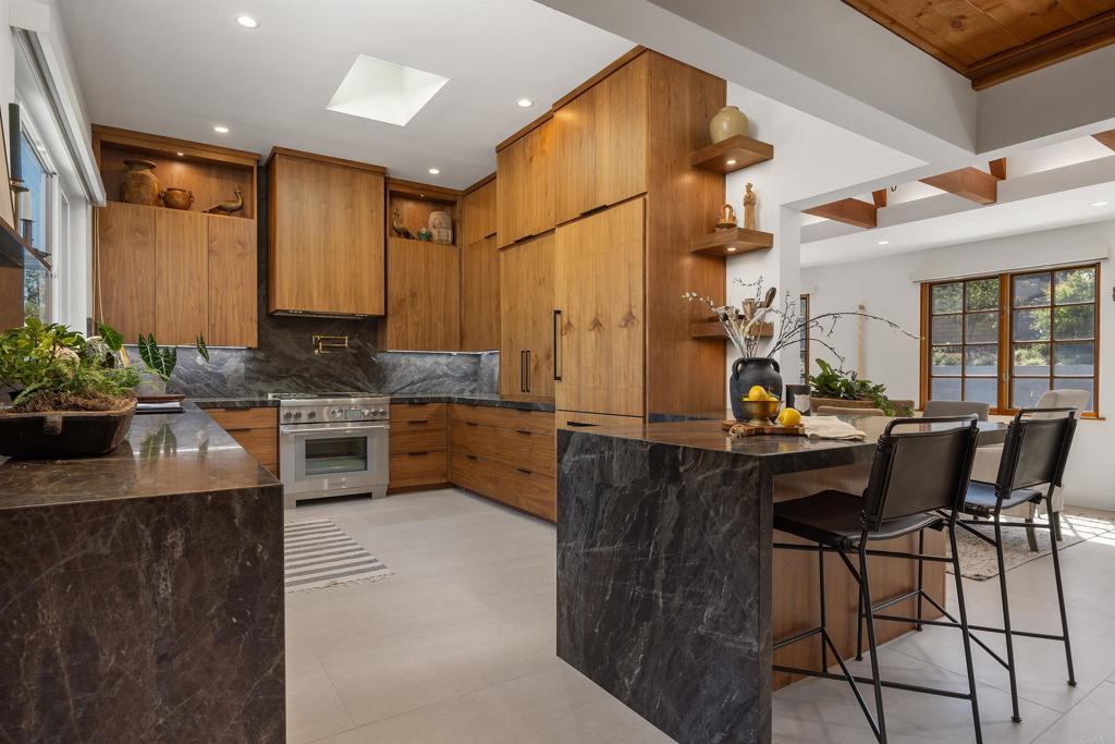 602 Sereno View Road Encinitas, CA 92024 - Photo 7 of 34 a kitchen with stainless steel appliances kitchen island granite countertop a stove a sink and a refrigerator