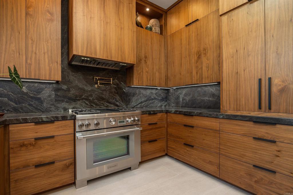 602 Sereno View Road Encinitas, CA 92024 - Photo 8 of 34 a kitchen with granite countertop wooden cabinets and white appliances