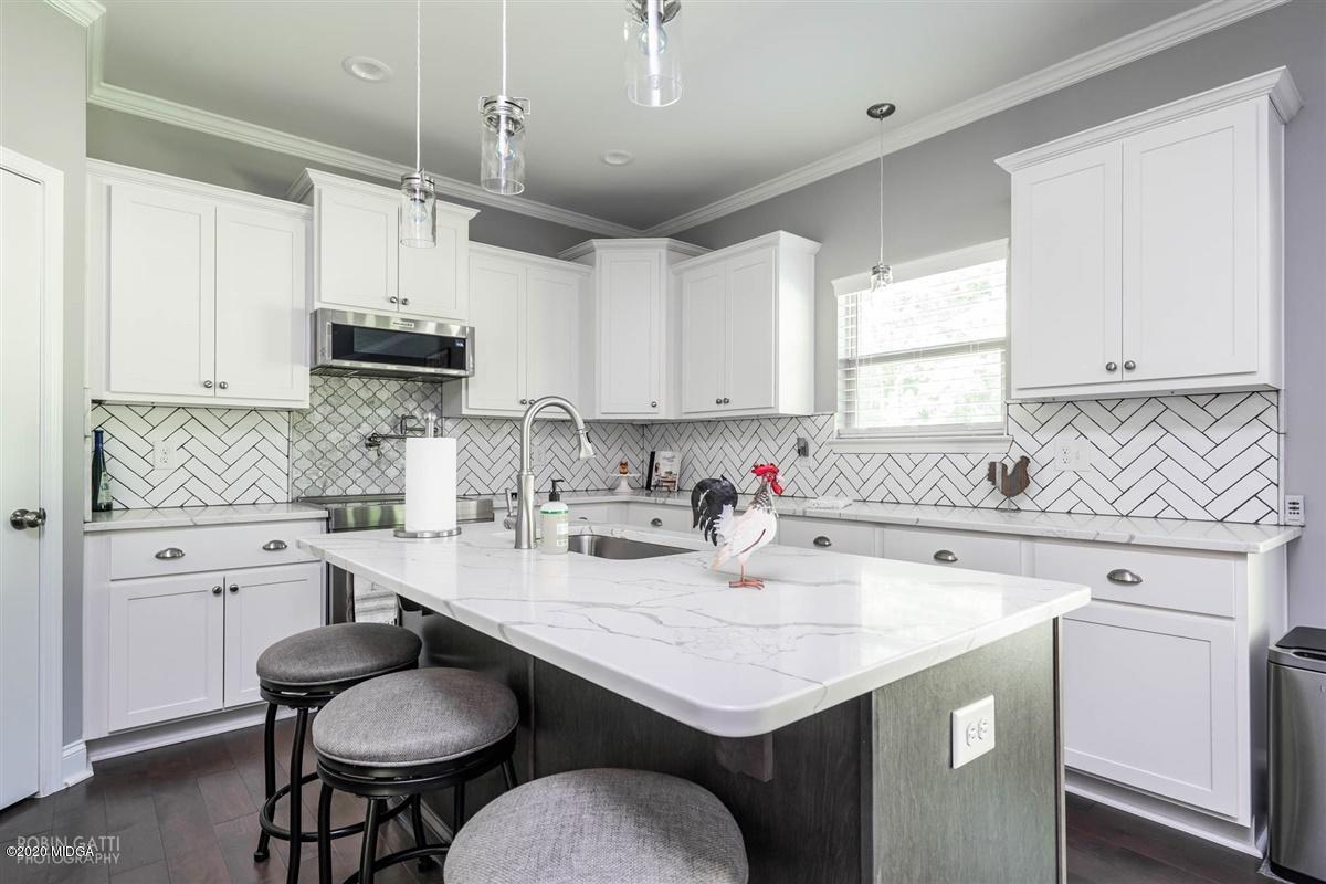 826 Holly Ridge Drive Gray, GA 31032 - Photo 11 of 28 a kitchen with kitchen island granite countertop a sink a stove a counter space and cabinets