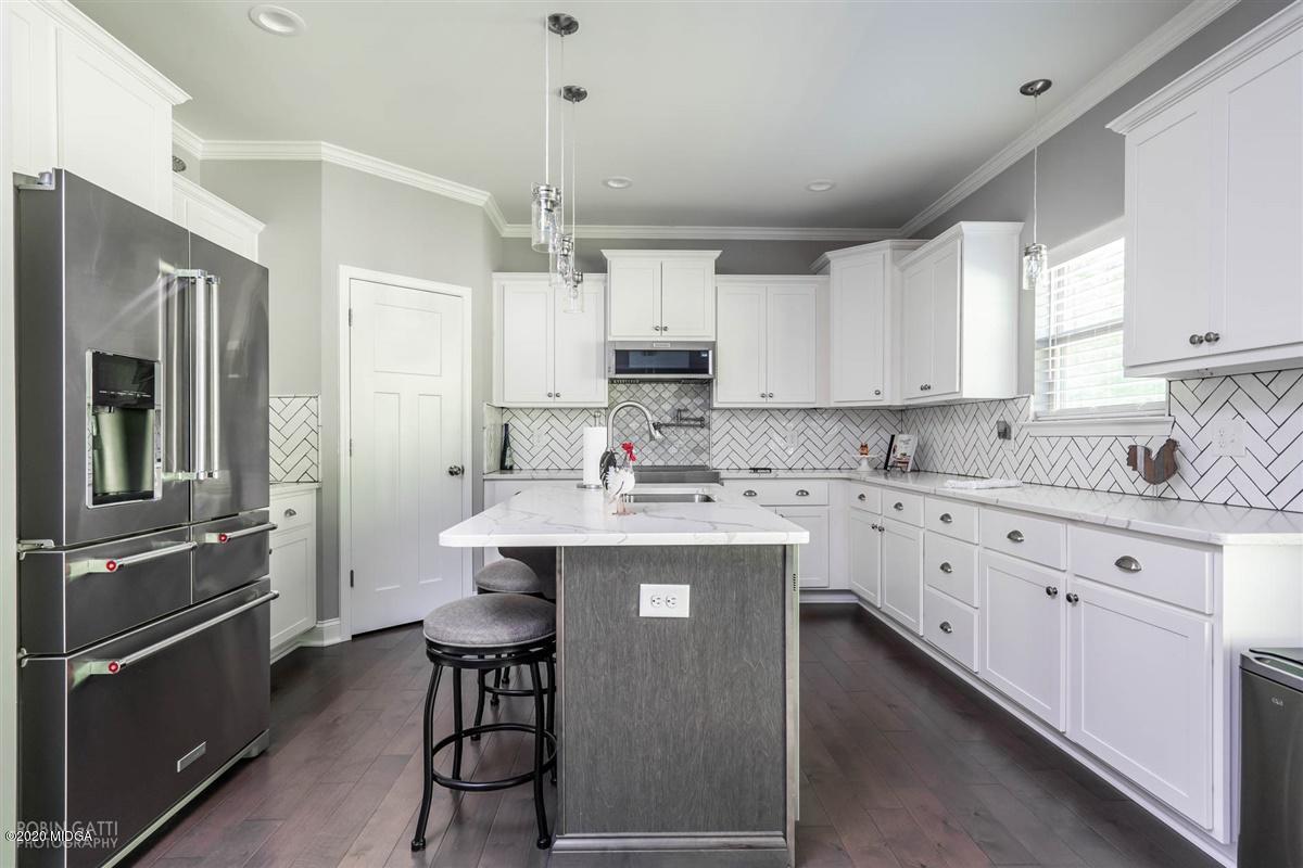 826 Holly Ridge Drive Gray, GA 31032 - Photo 10 of 28 a kitchen with stainless steel appliances granite countertop a sink dishwasher a refrigerator and white cabinets with wooden floor
