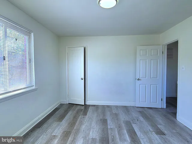 a view of a room that has wooden floor and windows in it