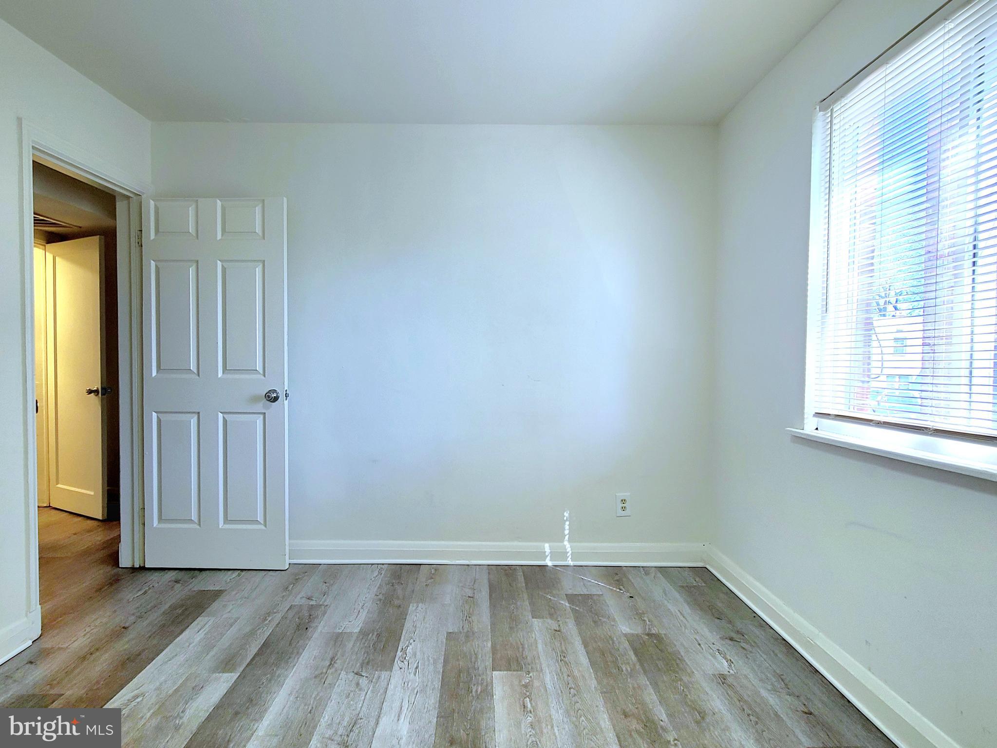 8520 Chestnut Oak Road Parkville, MD 21234 - Photo 25 of 28 an empty room with wooden floor and windows