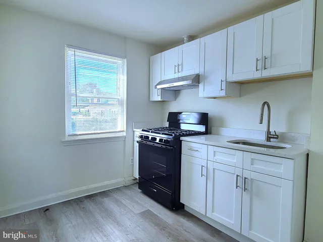 a kitchen with a sink stove and cabinets