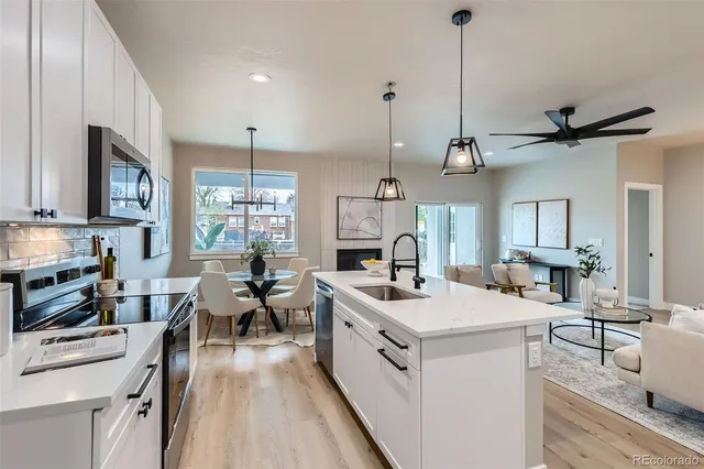 a view of a kitchen with kitchen island a sink a counter space appliances and cabinets