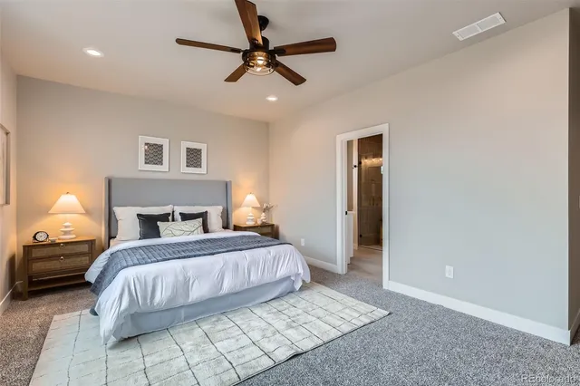 a bedroom with a large bed and a ceiling fan