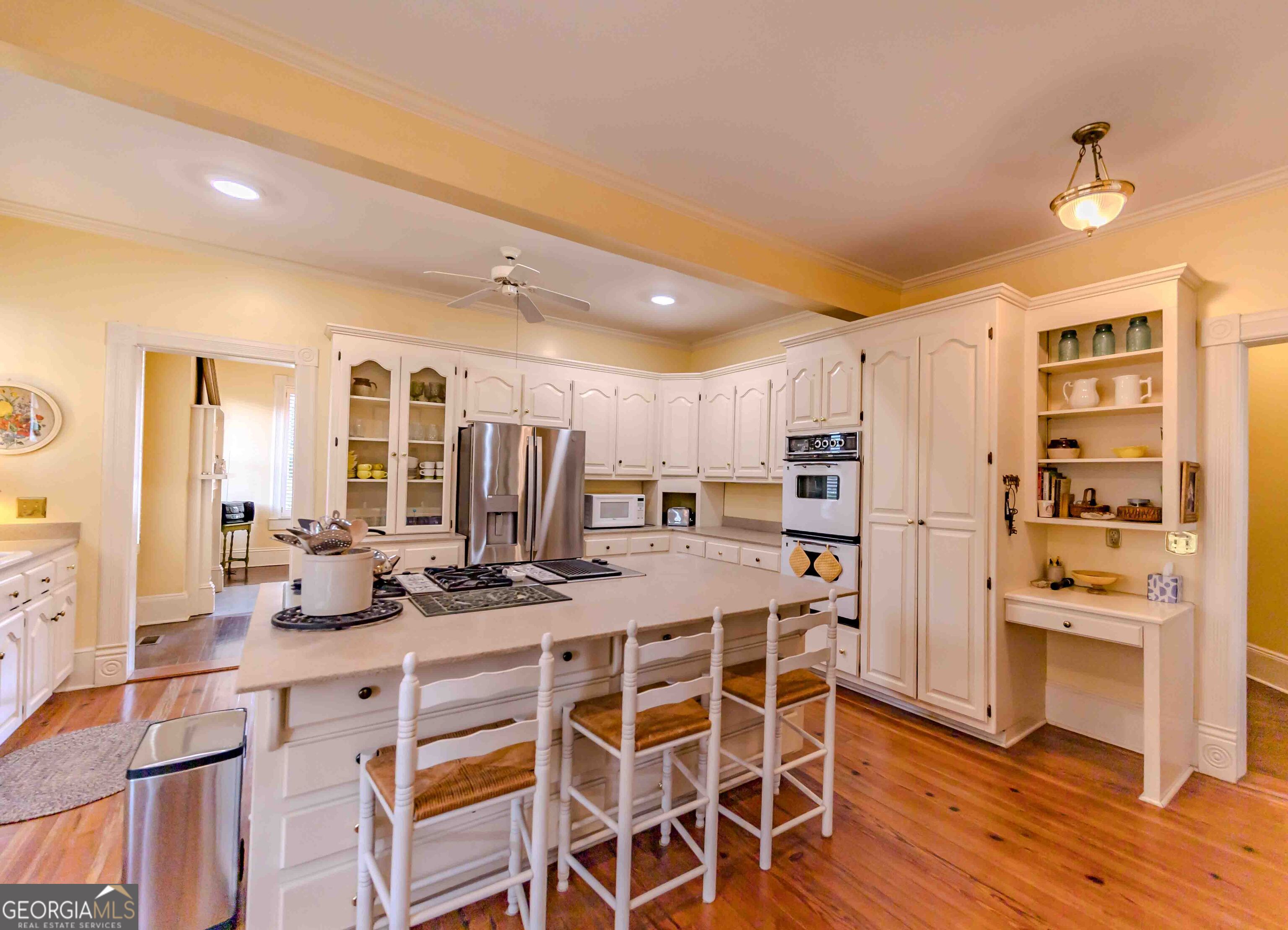 39 West Graham Street McRae-Helena, GA 31055 - Photo 28 of 107 a kitchen with stainless steel appliances kitchen island granite countertop a stove a refrigerator and white cabinets with wooden floor