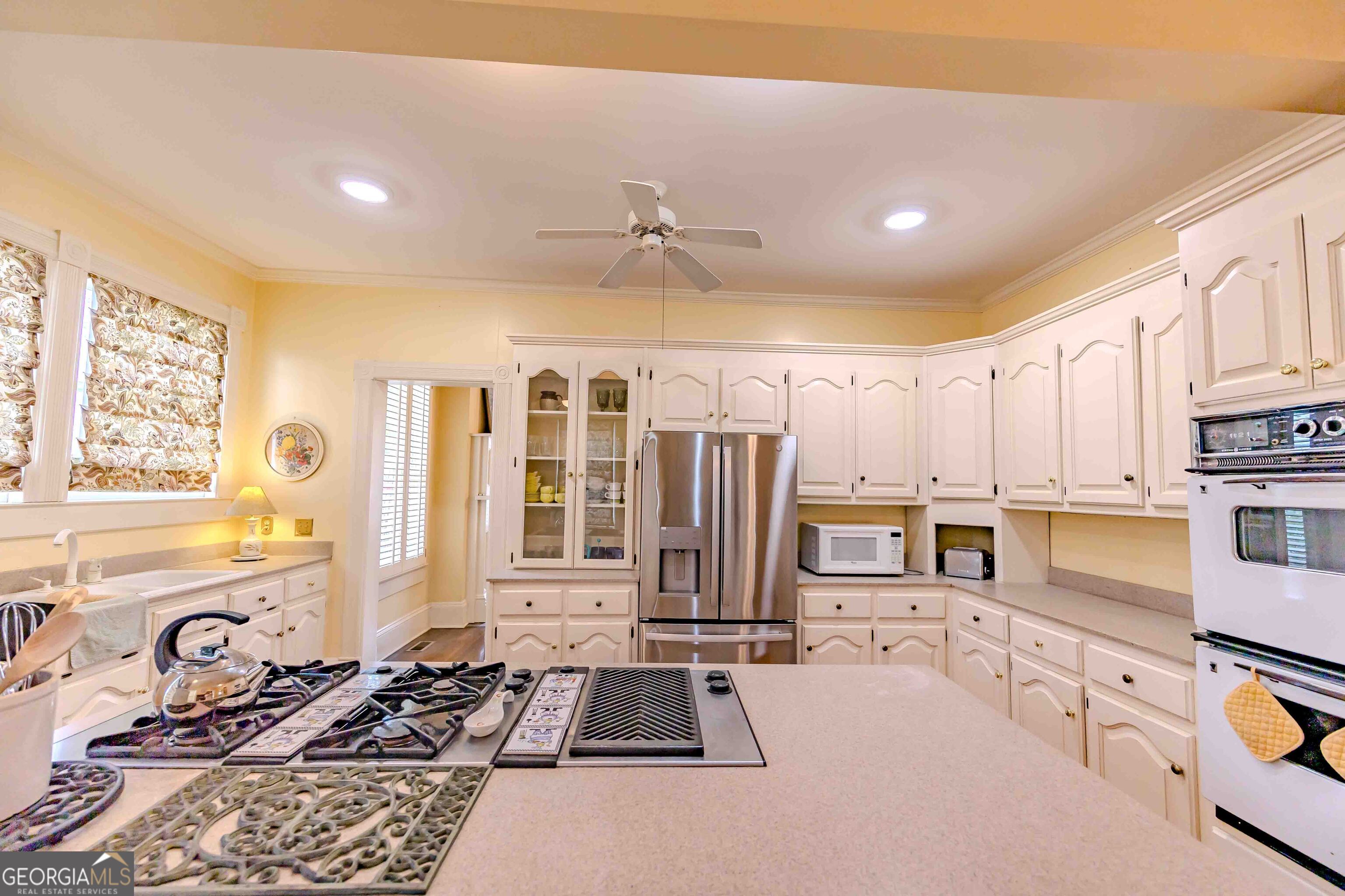 39 West Graham Street McRae-Helena, GA 31055 - Photo 29 of 107 a kitchen with stainless steel appliances a stove a sink and white cabinets with wooden floor