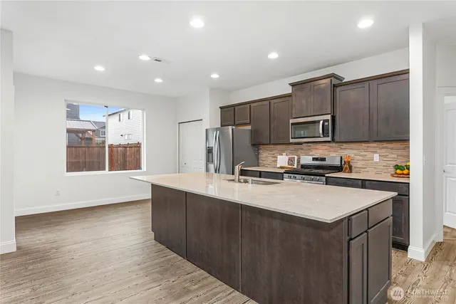 a kitchen with kitchen island a counter top space stainless steel appliances and cabinets