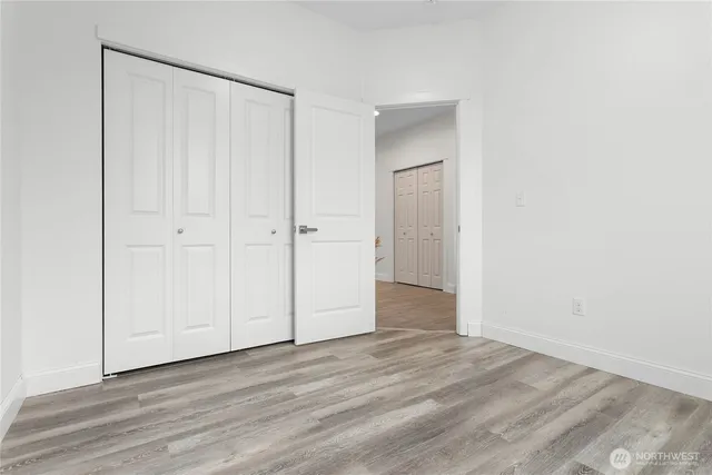 a view of an empty room with wooden floor